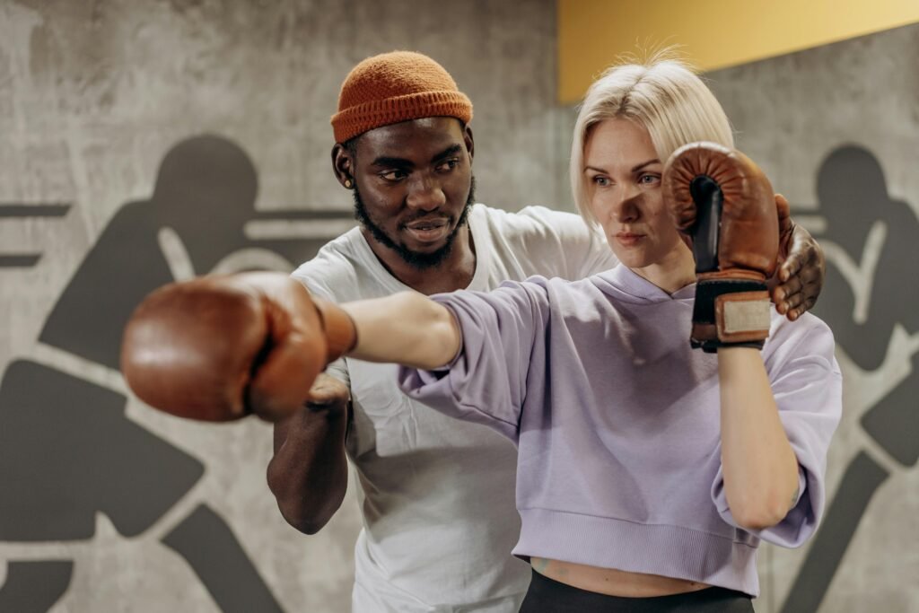 Coach sportif utilisant un outil IA pour analyser et améliorer un entraînement de boxe en salle de sport